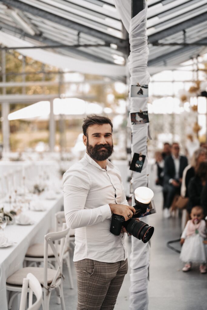 Ein Mann hält eine Kamera bei einer Hochzeitsfeier.